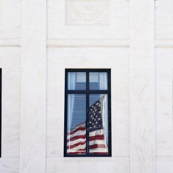 The US flag is reflected on a window of the US Supreme Court, as its justices are set to hear oral arguments on President Trump's bid to preserve sweeping tariffs after lower courts ruled that Trump overstepped his authority, in Washington, DC. Photo taken on November 5, 2025. 