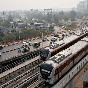 Metro trains move past commuters near the Sabarmati Metro station in Ahmedabad, India. Picture taken on January 31, 2026. 