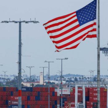 A US flag flutters near shipping containers at the Port of Los Angeles in California, May 2025. 