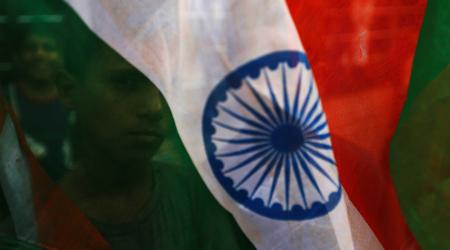 A boy's face is seen through the Indian national flag in Mumbai, India. 