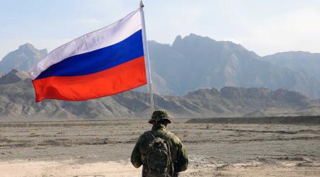A Russian soldier holds the Russian national flag, on Wednesday, August 24, 2022. 