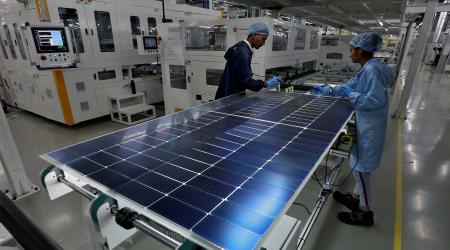 Workers assemble Photovoltaic Modules at the plant of Adani Green Energy Ltd (AGEL) in Mundra, India, April 11, 2024. 