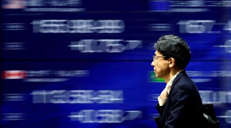 A man walks past an electronic screen displaying the current Japanese Yen exchange rate against the U.S. dollar and other foreign currencies in Tokyo, Japan May 2, 2024. 