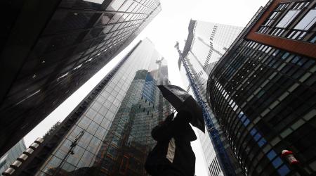 A person walks through a business district during rainy weather. 