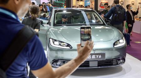 A potential buyer takes photos of an EV at the exhibition area of new EVs at China's Import and Export Fair (Canton Fair), in Guangdong Province, China. Picture taken on April 15, 2024. 