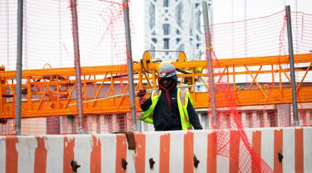 A construction worker carries a steel bar at the site of a large public infrastructure reconstruction project in New York. April 22, 2021