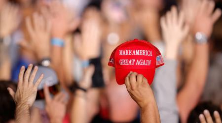 A supporter of Republican presidential nominee and former U.S. President Donald Trump holds a MAGA hat during a rally at Gaylord Rockies Resort and Convention Center in Aurora, Colorado, U.S., October 11, 2024.