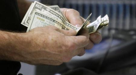 A customer counts his cash at the register in Flushing, New York