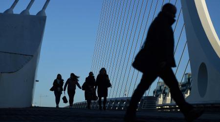 Commuters make their way into work in the morning in the financial district of Dublin, Ireland. 