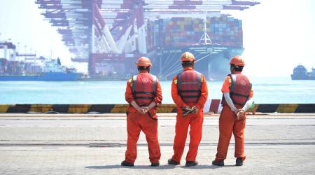 Workers stand at the port of Qingdao, Shandong province, China. 