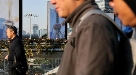 People walk in the financial district of Pudong in Shanghai, China, January 16, 2025.