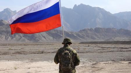 A Russian soldier holds a Russian national flag during training. 