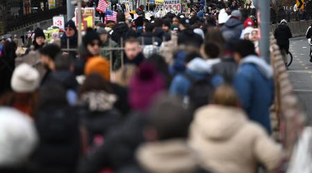 People walk along the Brooklyn Bridge on the bridge's Manhattan side promenade entrance, on January 1, 2024. 