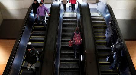 Commuters walk on the escalator at a metro station in Washington, DC. 