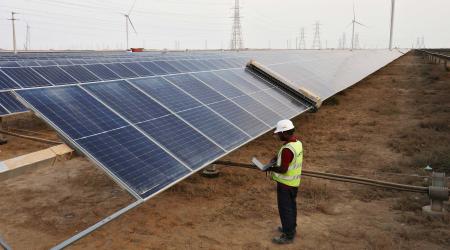 A technician checks solar panels in Khavda, India. Photo taken on April 12, 2024. 