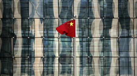 A Chinese national flag flutters at the headquarters of a commercial bank in central Beijing, China. 