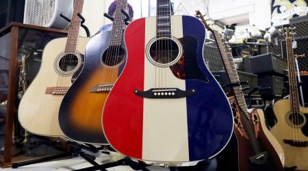 A selection of guitars is displayed at a music store. 