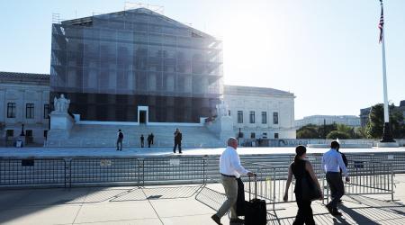 People walk past the US Supreme Court building, where oral arguments are scheduled for November 5, challenging President Trump's authority to impose certain tariffs using the International Emergency Economic Powers Act. Picture taken on October 6, 2025. 