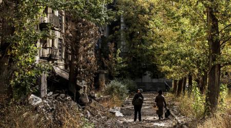 Residents walks near apartment buildings damaged by a Russian military strike, amid Russia's attack on Ukraine, in the frontline town of Kostiantynivka in Donetsk region, Ukraine October 13, 2025. 