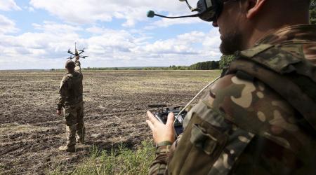 A Ukranian soldier holds a UAV as another soldier wears a headset during the training of drone pilots, Ukraine. Photo taken on August 12, 2025.