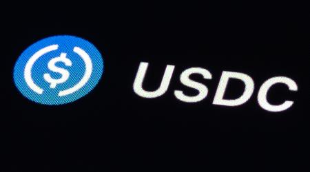 The stablecoin USD Coin (USDC) logo is displayed on a screen. 