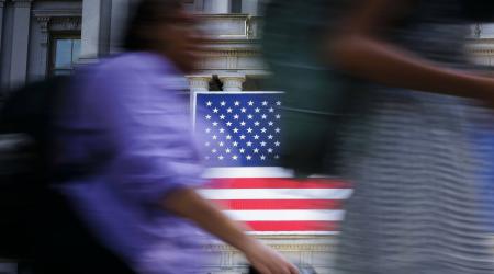 The US flag is shown hanging from a government building in Washington, DC. 