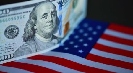 US banknote and flag are displayed in this photo illustration taken on December 11, 2025. 