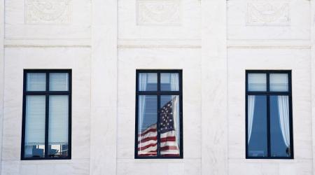 The US flag is reflected on a window of the US Supreme Court, as its justices are set to hear oral arguments on President Trump's bid to preserve sweeping tariffs after lower courts ruled that Trump overstepped his authority, in Washington, DC. Photo taken on November 5, 2025. 