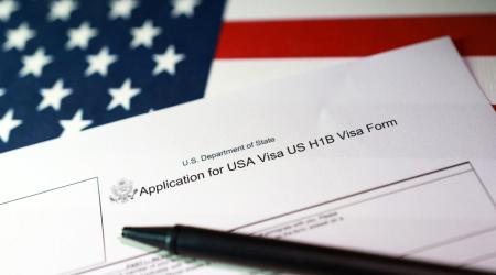 A US flag and H-1B Visa application form are seen in this photo illustration, taken on September 22, 2025. 