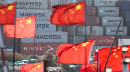 Chinese national flags flutter near shipping containers at the Yangshan Port outside Shanghai, China. Photo taken on February 7, 2025. 