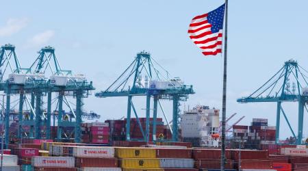 An American flag flies in front of shipping containers at the Port of Los Angeles, CA. May 13, 2025. 