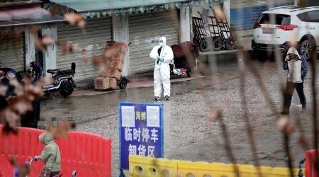A worker in a protective suit is seen at the closed seafood market in Wuhan, Hubei province, China January 10, 2020. REUTERS/Stringer/File Photo CHINA OUT