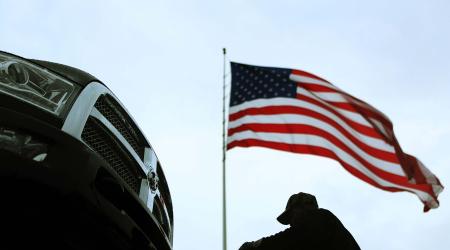 An auto carrier driver unloads a new Ram pickup truck in Gaithersburg, Maryland November 7, 2013. 