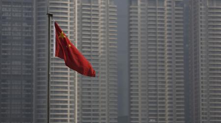 A Chinese flag is seen in front of the financial district of Pudong in Shanghai, China, January 19, 2016. 