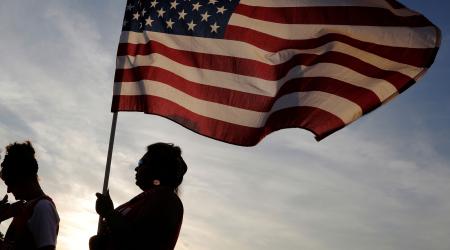 A voter holds a U.S. flag during a sign waving rally with supporters of U.S. President Donald Trump on a sidewalk in the Pinellas County city of Clearwater, Florida, U.S., May 15, 2019. 