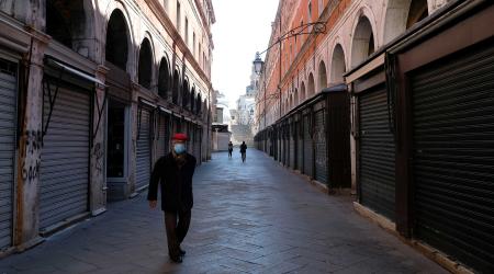 A man wearing a protective mask in an empty street of Venice on Sunday with an unprecedented lockdown across of all Italy imposed to slow the outbreak of coronavirus, in Venice, Italy, March 15, 2020.