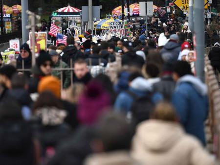 People walk along the Brooklyn Bridge on the bridge's Manhattan side promenade entrance, on January 1, 2024. 