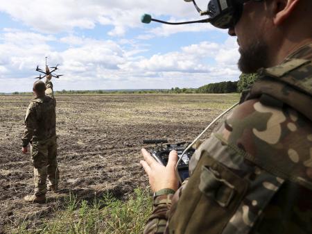 A Ukranian soldier holds a UAV as another soldier wears a headset during the training of drone pilots, Ukraine. Photo taken on August 12, 2025.