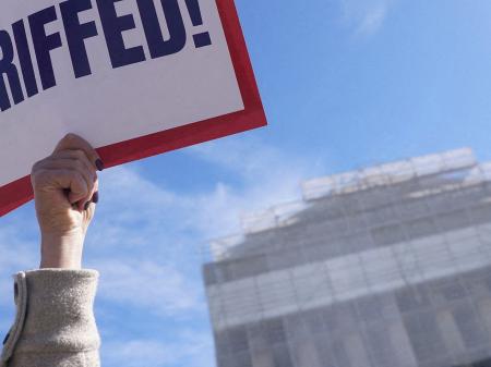 A protester against Trump’s tariffs holds a sign outside the US Supreme Court, as its justices are set to hear oral arguments on the President’s bid to preserve sweeping tariffs, in Washington, DC. Picture taken on November 5, 2025. 