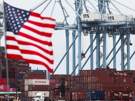 A US flag flutters in front of shipping containers at the Port of Long Beach in Long Beach, California. Photo taken on July 11, 2025. 