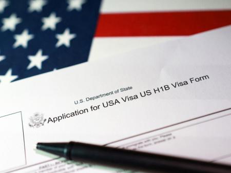 A US flag and H-1B Visa application form are seen in this photo illustration, taken on September 22, 2025. 