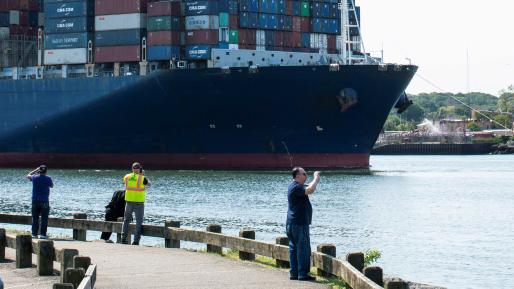 :  People take a look at a container ship entering Newark bay to dock in Elizabeth port as seen from Bayonne, New Jersey, U.S., May 20, 2021