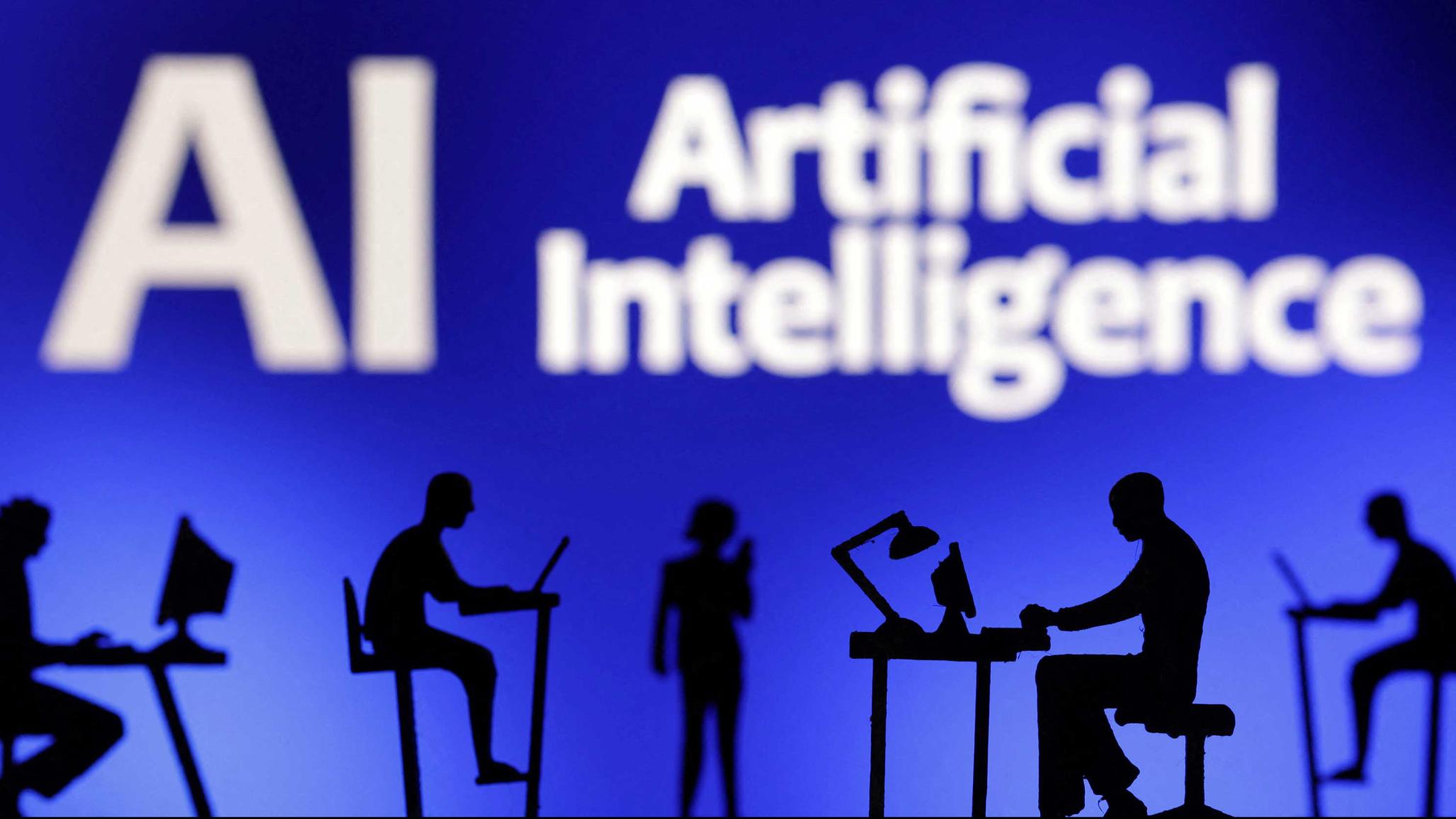 Figurines with computers and smartphones are seen in front of the words "Artificial Intelligence AI" in this illustration taken, February 19, 2024. 