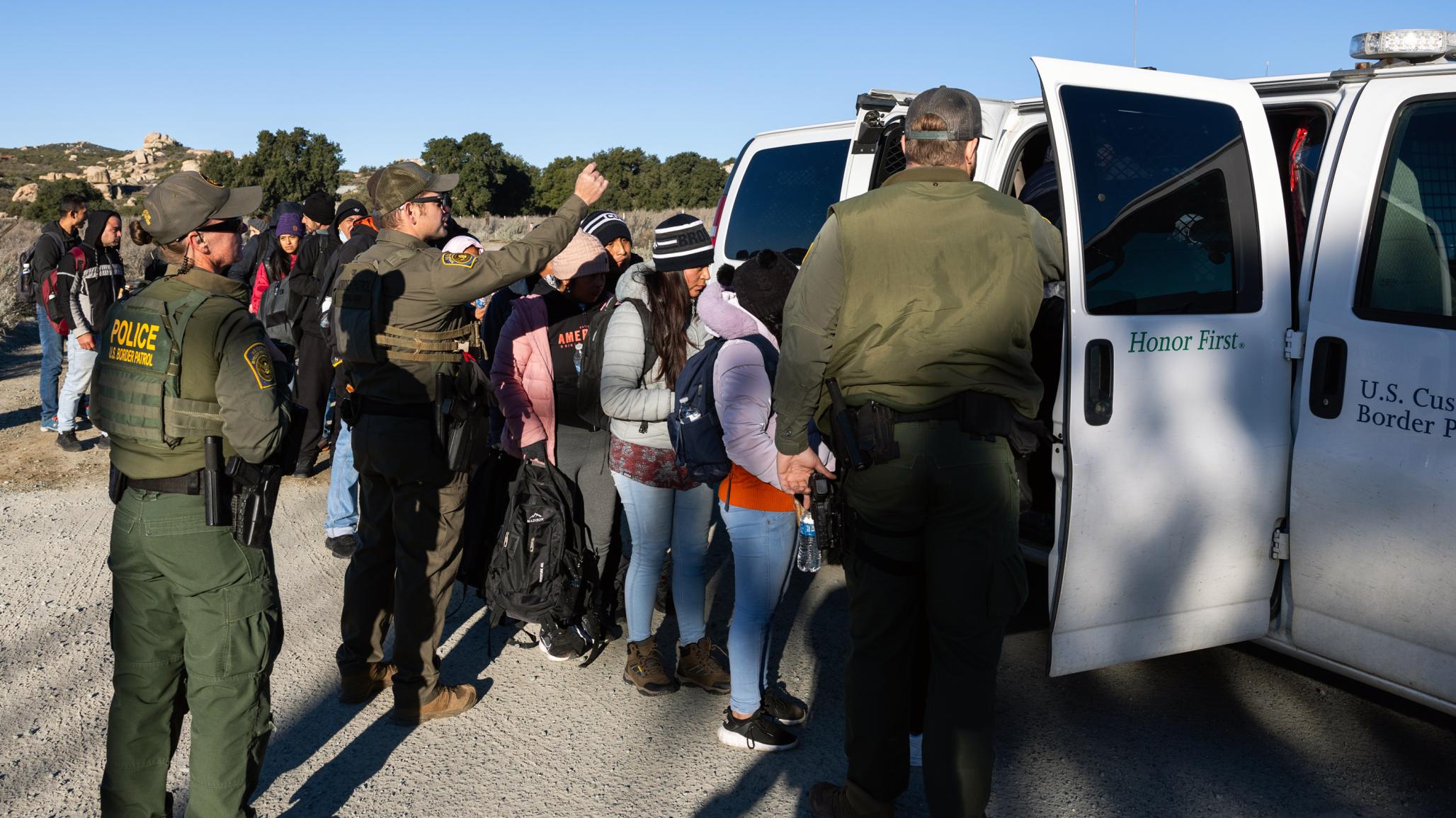 Migrants get on the patrol vehicle of the U.S. Border Patrol on February 13, 2024 in San Diego, California. VCG/Qian Weizhong