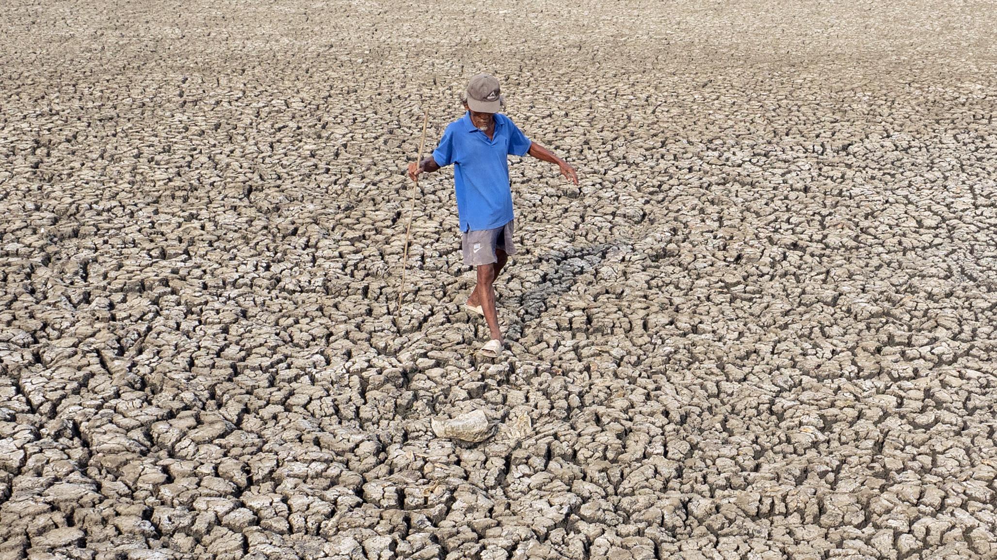 A resident observes the condition of the receding fishpond due to the El Nino phenomenon in Indonesia. Picture taken on October 17, 2023.