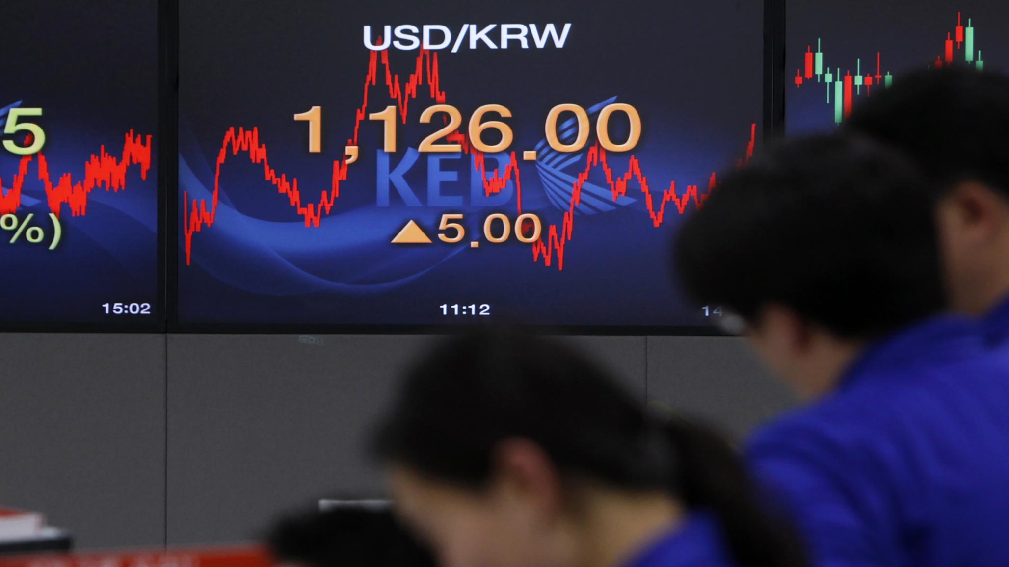 Currency dealers work in front of screens displaying the exchange rate between the US dollar and Korean won, in Seoul, South Korean, on January 5, 2011. REUTERS/Truth Leem