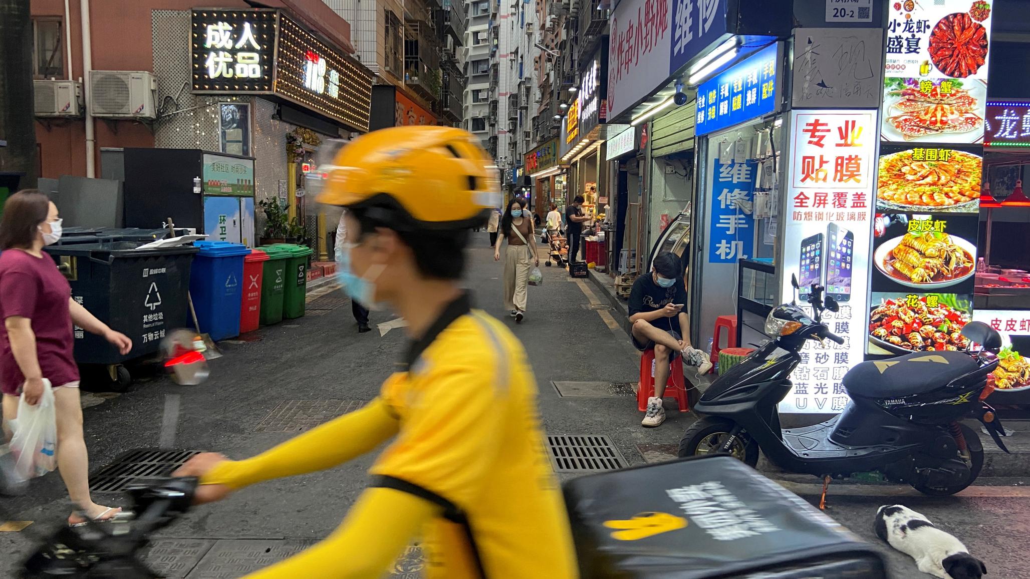 A food delivery worker rides past an urban village in Shenzhen's Futian district, Guangdong province, China May 31, 2022. Picture taken May 31, 2022. 