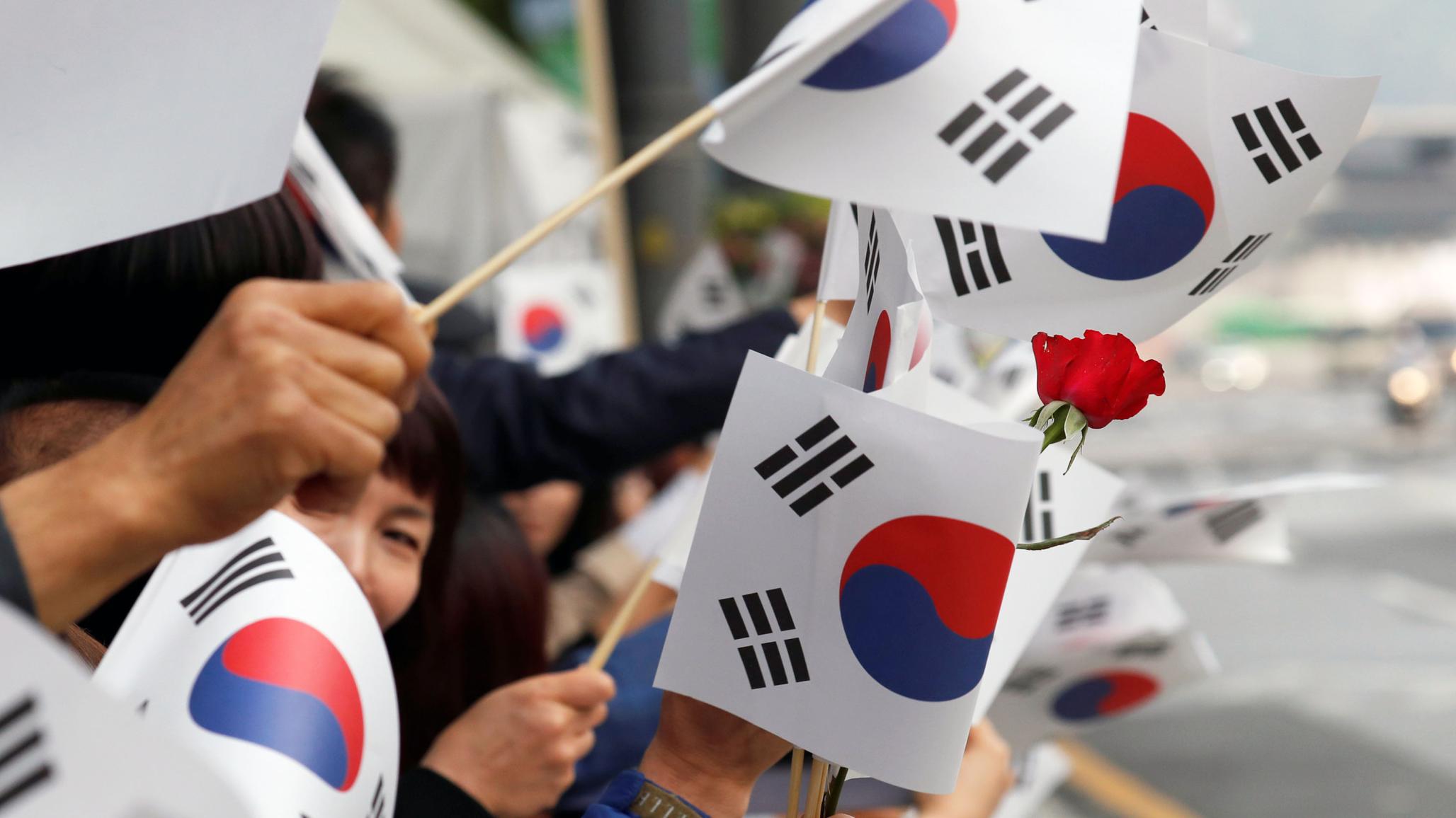 People wave South Korean flags in Seoul, South Korea. 