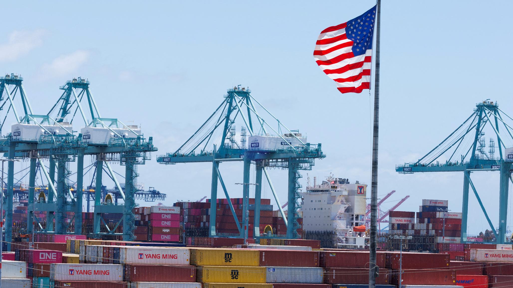 An American flag flies in front of shipping containers at the Port of Los Angeles, CA. May 13, 2025. 