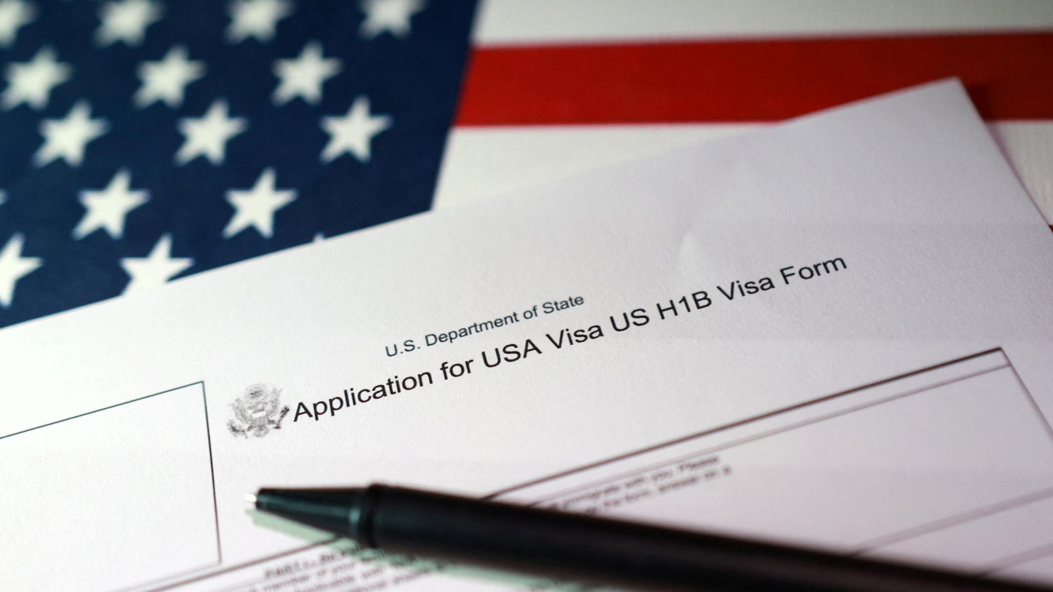 A US flag and H-1B Visa application form are seen in this photo illustration, taken on September 22, 2025. 